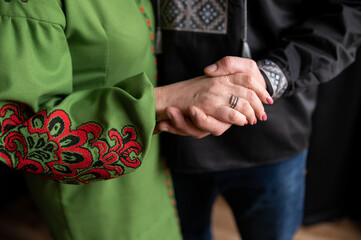 husband and wife holding hands. Dressed in Ukrainian folk clothes