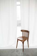 white curtains and old wooden chair in photo studio