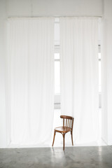 white curtains and old wooden chair in photo studio