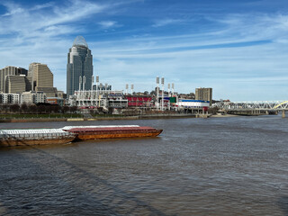 Barge traveling down the Ohio River, with the Cincinnati, Ohio skyline in the background