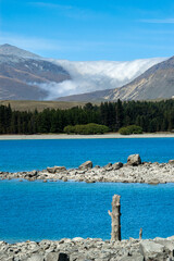 Takapo lake view in south island, new zealand with mountains and sea of clouds in the background