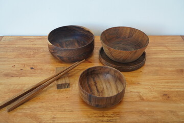 Obraz na płótnie Canvas Wooden bowl, chopsticks, ecofriendly concept. set of wooden tableware on wooden table