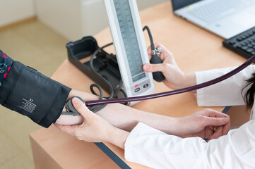 The doctor measures the patient's blood pressure. High blood pressure. Doctor's office.