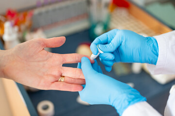 The doctor measures the patient's C-reactive protein (CRP). The doctor draws blood from the...