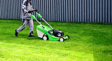 Lawn mover on green grass in modern garden. Machine for cutting lawns.