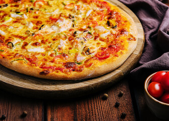 Delicious pizza with seafood on wooden stand