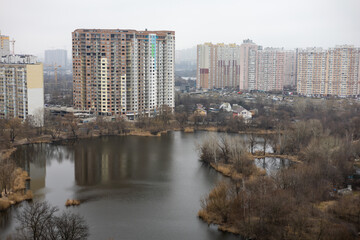 Soviet prefabricated multi-storey apartment building near lake in Kyiv, Ukraine. - obrazy, fototapety, plakaty