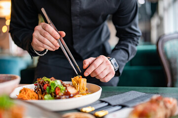 chef hands decorated food on plate in restaurant