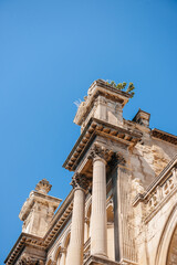 A vintage; historical landmark in Aix-en-Provence with a picturesque rooftop and bright blue columns bathed in South Frances sunny sky.