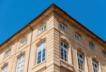 A grand, blue building stands tall in the French city of Provence. Its impressive facade and intricate architecture are a prime investment property with no people in sight against a clear sky backdrop