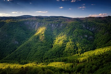Obraz premium Spring green mountain landscape with amazing sunlight. Wild mountain valley, warm spring day. Discover the beauty of spring nature
