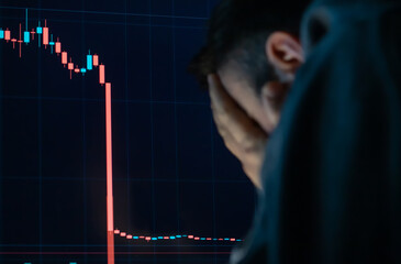 Frustrated depressed man holding head in hands shocked when global stock market going down. - 582133800