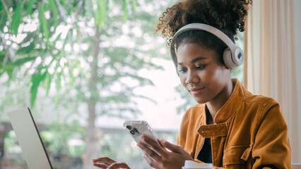 Using headphones. Young african american university foreign exchange students study online on laptop pc english language class by international specialists with master at cafe.