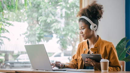 Using headphones. Young african american university foreign exchange students study online on laptop pc english language class by international specialists with master at cafe.