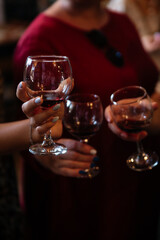 Wine tasting. Women hold three glasses of homemade wine in their hands