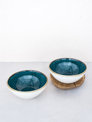 Two empty blue soup bowlson table on white background for your copy. Two blue handmade ceramic soup...