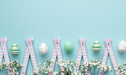 Easter concept for construction companies. Easter egg and spring flowers with folding meter on the...