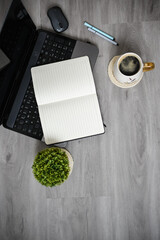 Working space at home, laptop, coffee mug and papers on wooden background
