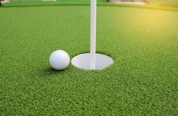 Golf ball next to hole - Sport , hobby and recreation concept