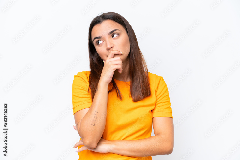 Sticker Young caucasian woman isolated on white background having doubts and with confuse face expression