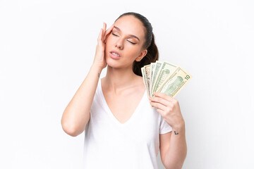Young caucasian woman taking a lot of money isolated on white background with headache
