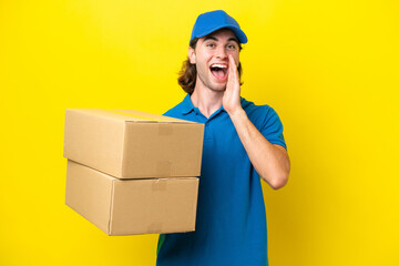 Delivery handsome man isolated on yellow background with surprise and shocked facial expression