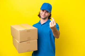 Delivery handsome man isolated on yellow background making money gesture