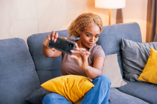 Woman taking selfies while enjoying leisure time at home