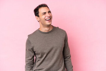 Young caucasian man isolated on pink background laughing