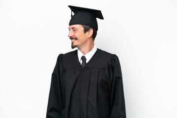 Young university graduate man isolated on white background looking side