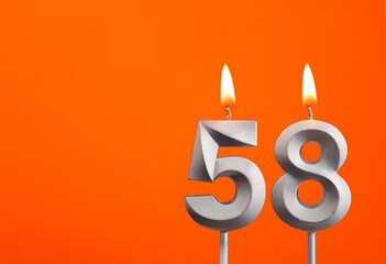 Number 58 - Silver Anniversary candle on orange background