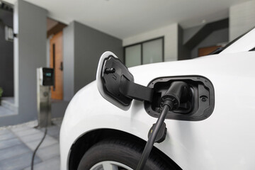 Closeup electric vehicle plugged-in with cable from charging point powered for progressive concept...