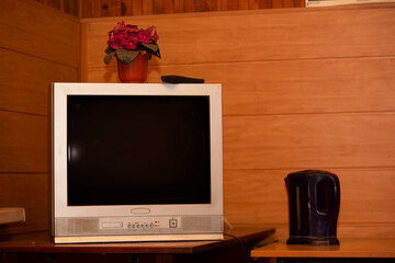 Retro TV on the table in the room on a wooden background.