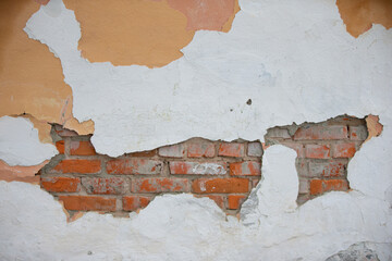 Texture of an old brick wall with peeling white paint.
