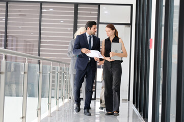 Young businessman and young female employees meeting using documents and laptop.