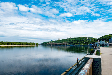 Obraz premium Kyiv bridge over the river with blue sky and clouds in summer