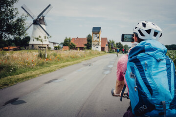 Frau macht während einer Fahrrad-Tour ein Foto von einer Windmühle, Niedersachsen, Deutschland