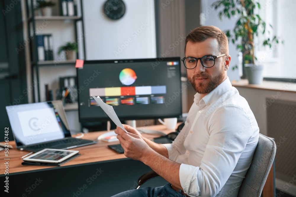 Poster graphic designer is sitting. man in formal clothes is working in the modern office. using computer