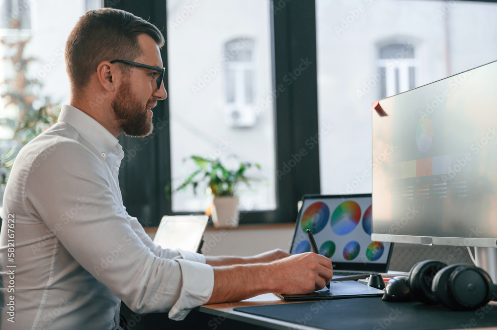 Poster man in formal clothes is working in the modern office. using computer