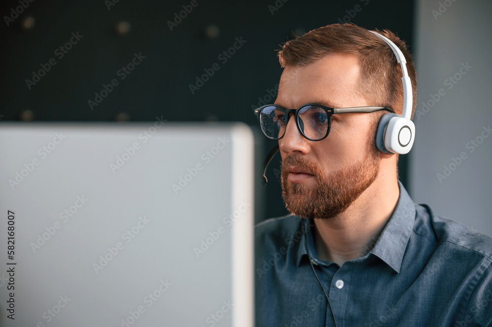 Poster portrait of man that is in formal clothes, working in the modern office. using computer