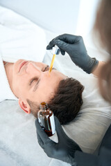 Obraz na płótnie Canvas Dermatologist apply serum for face of redness on man skin