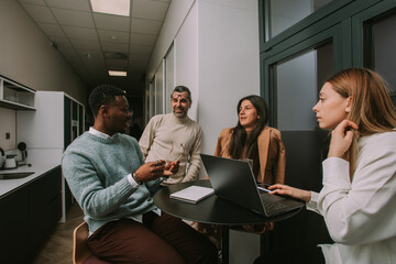 Inter-generational diverse group of business people discussing their next project at the office after the working shift