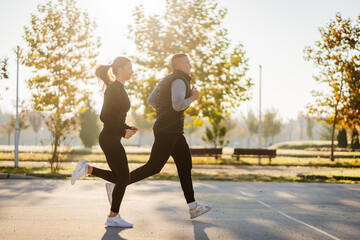 Obraz premium Male and female fitness instructors working out together in the park