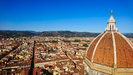 Fototapeta na wymiar Firenze, Italy - April 7, 2018: aerial view of Florence cityscape and skyline with Brunelleschi's Dome on the right under bright blue sky