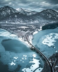 Vertical shot of a road over the frozen Lake Sylvenstein surrounded by hills in Bavaria, Germany