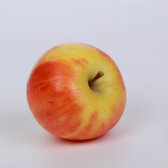 Red and yellow apple on a white surface