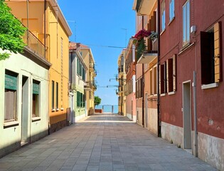 Fototapeta na wymiar Beautiful shot of a sunny alley with stone buildings in Murano, Italy
