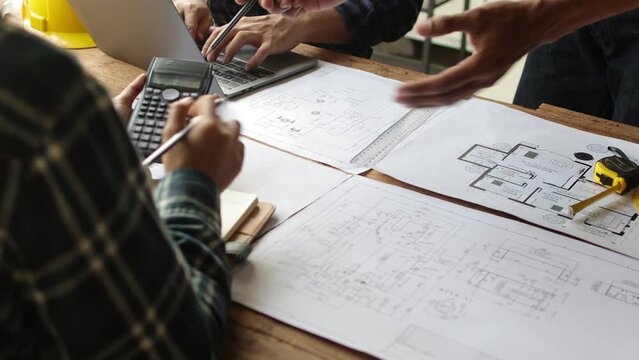 Architect team meeting, Group of architects and contractor engineers meet to discuss the design and layout of the construction project.