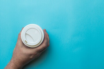 A hand holding a coffee cup