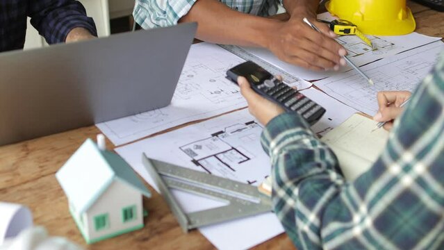 Architect team meeting, Group of architects and contractor engineers meet to discuss the design and layout of the construction project.